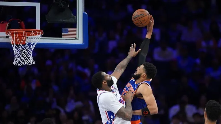 New York Knicks' Karl-Anthony Towns, right, goes up for a dunk against Philadelphia 76ers' Andre Drummond